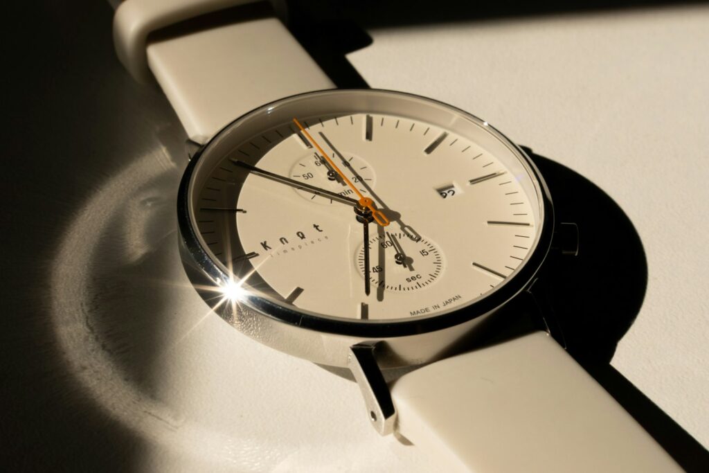 A minimalist white wristwatch with a clean dial