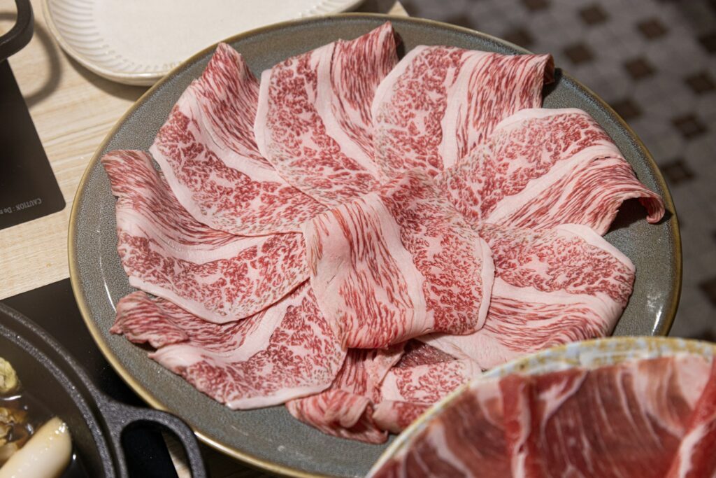 Thinly sliced raw beef arranged on a plate
