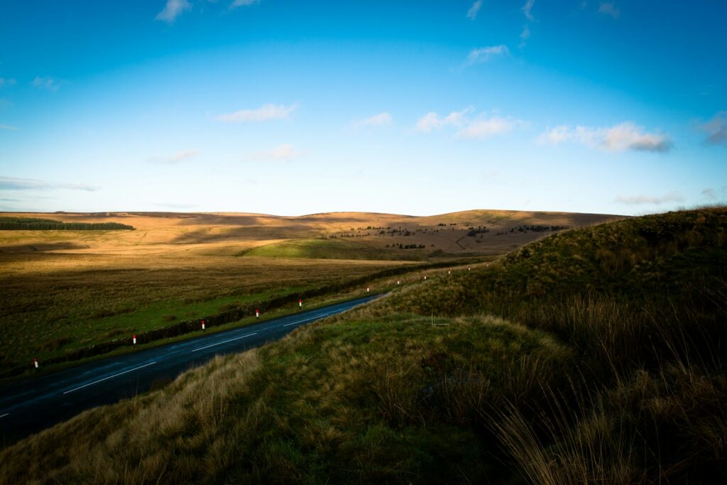 A winding road through rolling hills under a blue sky
