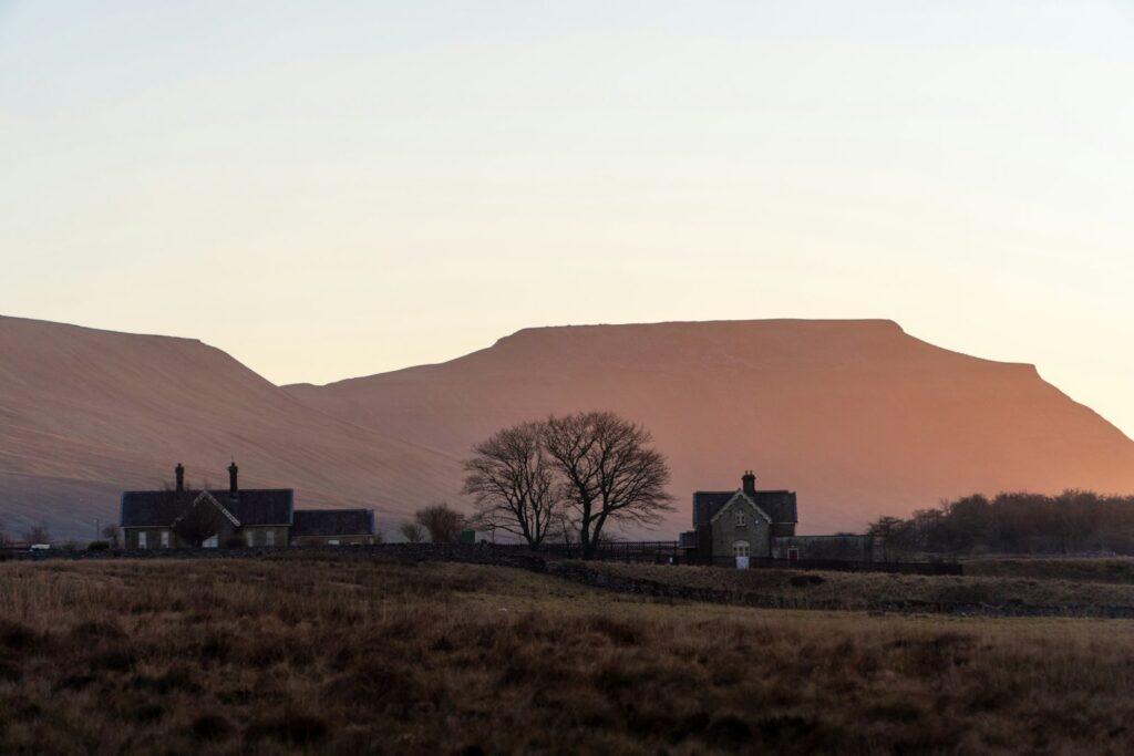 Rural houses nestled against a mountain at sunset