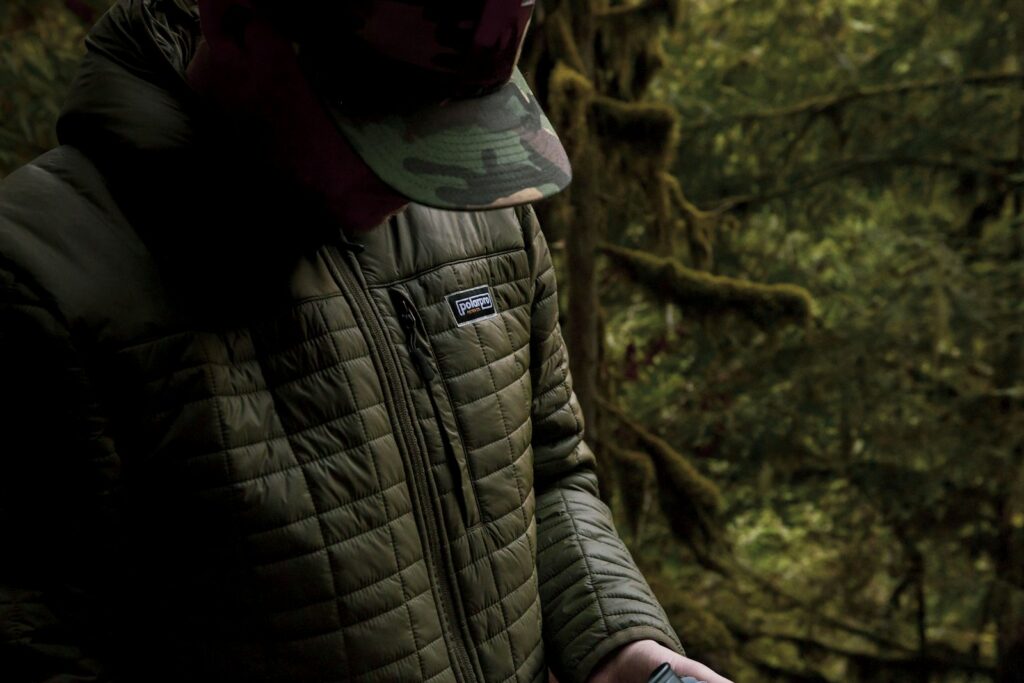 A person wearing a jacket and holding a cell phone