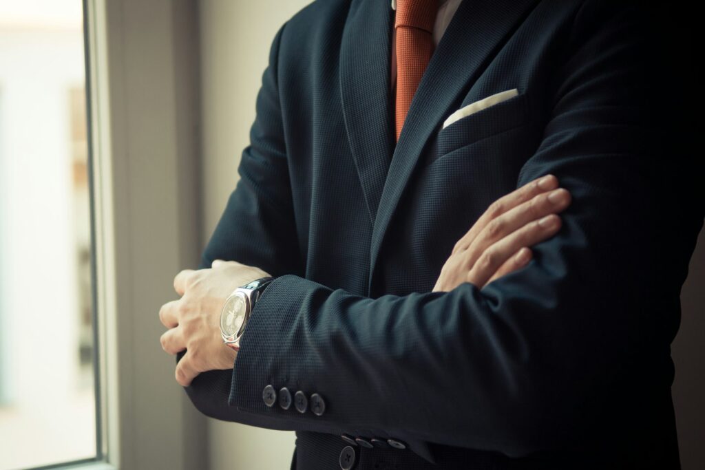 Man in black suit jacket wearing silver watch