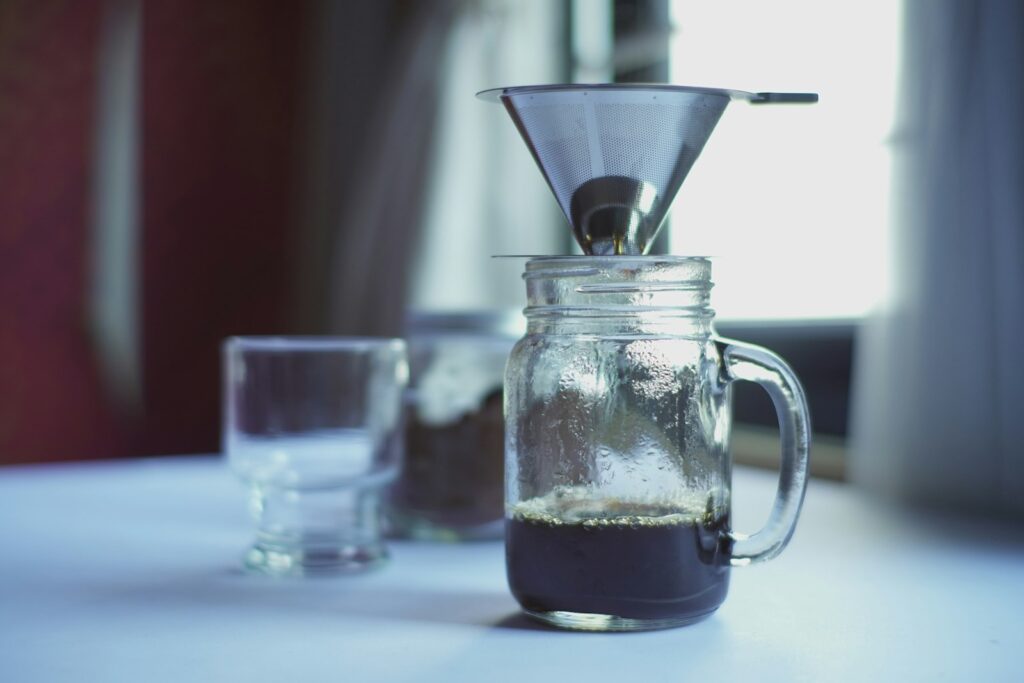 Clear glass pitcher with white plastic cup