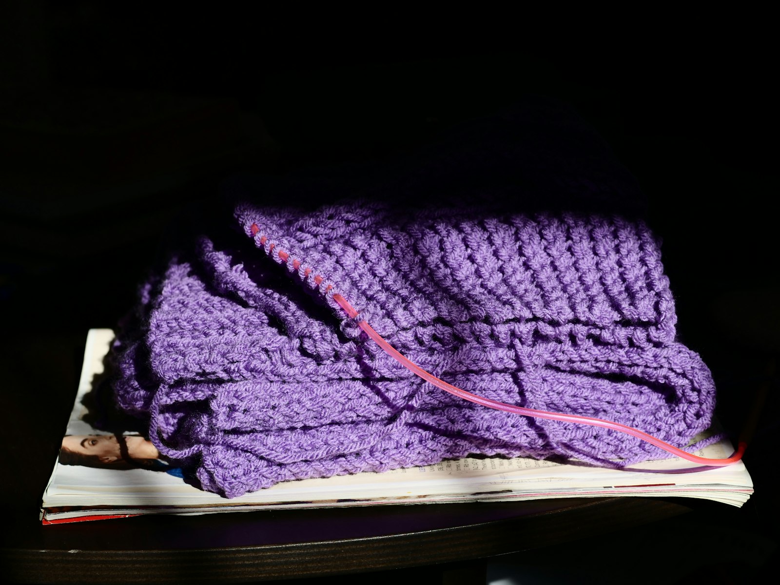 Purple knitted fabric with pink thread on books