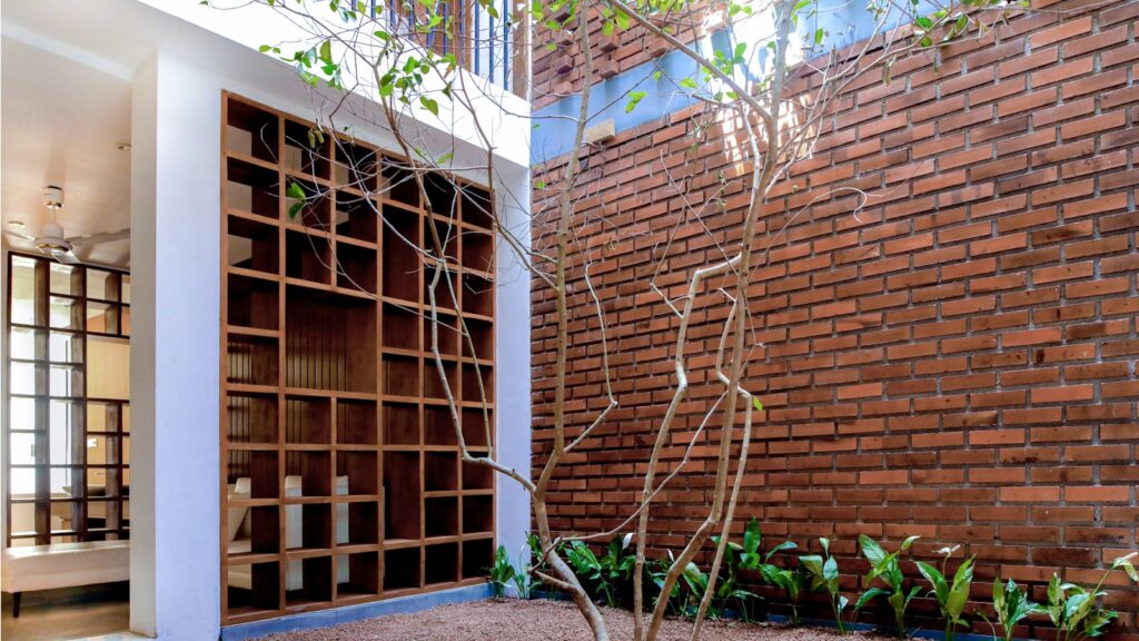 A room with a brick wall and a tree in the corner